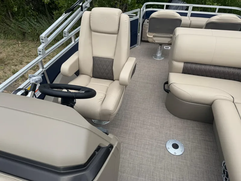 Slide: The Image of 2025 Sun Tracker Fishin' Barge 22 XP3 interior with beige seating and steering wheel. - 10