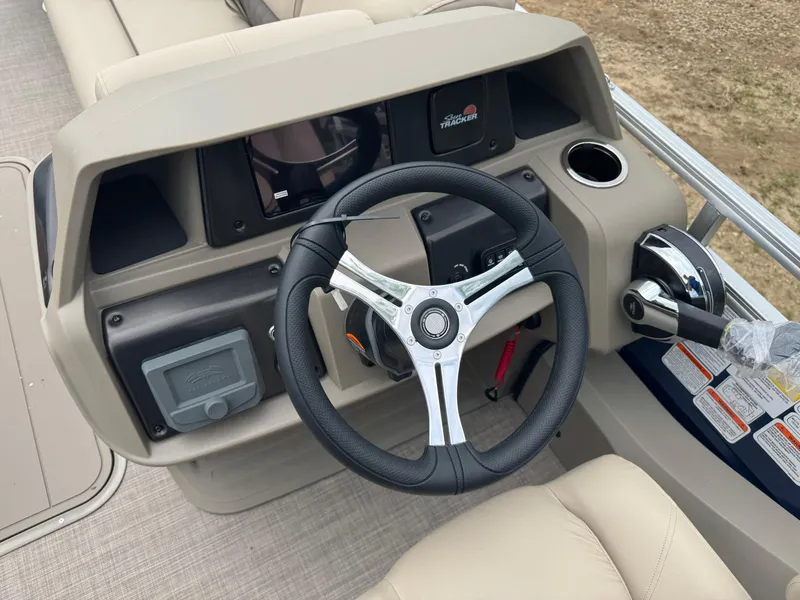 Slide: The Image of 2025 Sun Tracker Fishin' Barge 22 XP3 steering console with modern controls and beige seating. - 12