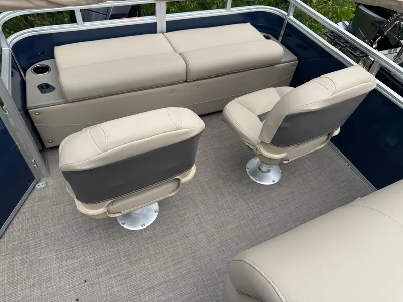 Slide: The Image of 2025 Sun Tracker Fishin' Barge 22 XP3 interior with beige seating and cup holders. - 13