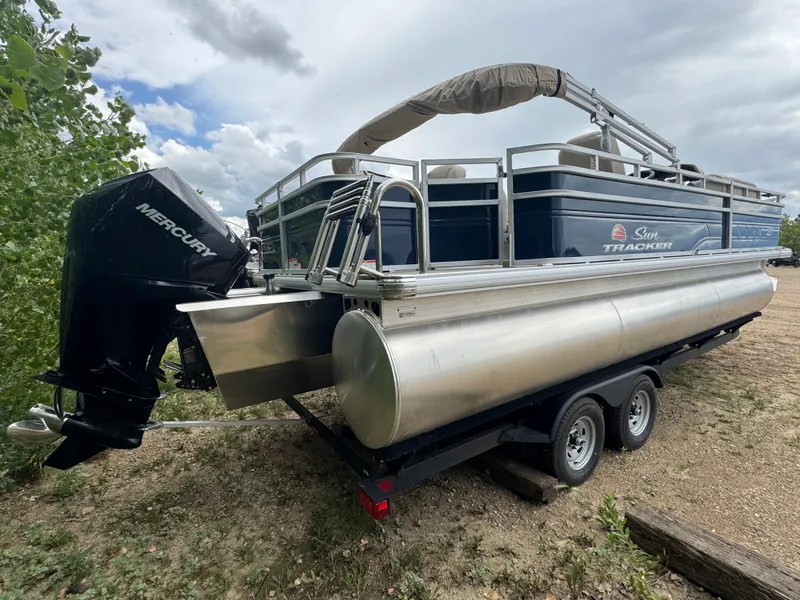 Slide: The Image of 2025 Sun Tracker Fishin' Barge 22 XP3 pontoon boat with Mercury engine on trailer. - 3