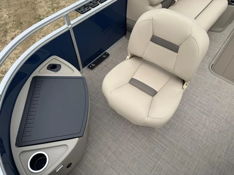 Slide: The Image of 2025 Sun Tracker Fishin' Barge 22 XP3 interior with beige seating and fishing station. - 6