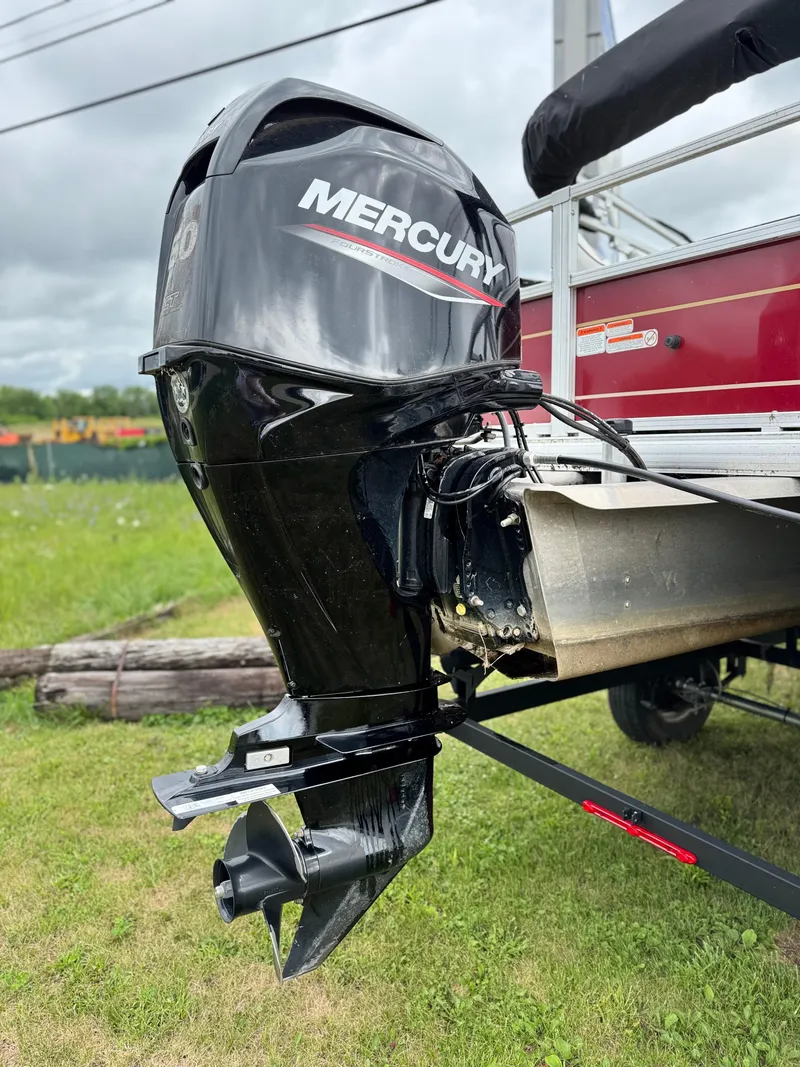Slide: The Image of 2022 Sun Tracker Bass Buggy 18 DLX with Mercury outboard motor on grassy field. - 10