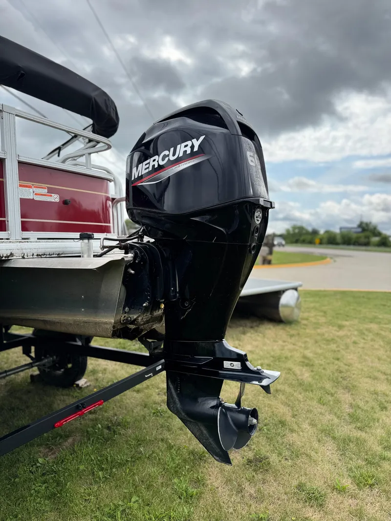 Slide: The Image of 2022 Sun Tracker Bass Buggy 18 DLX with Mercury outboard motor on grassy area. - 11