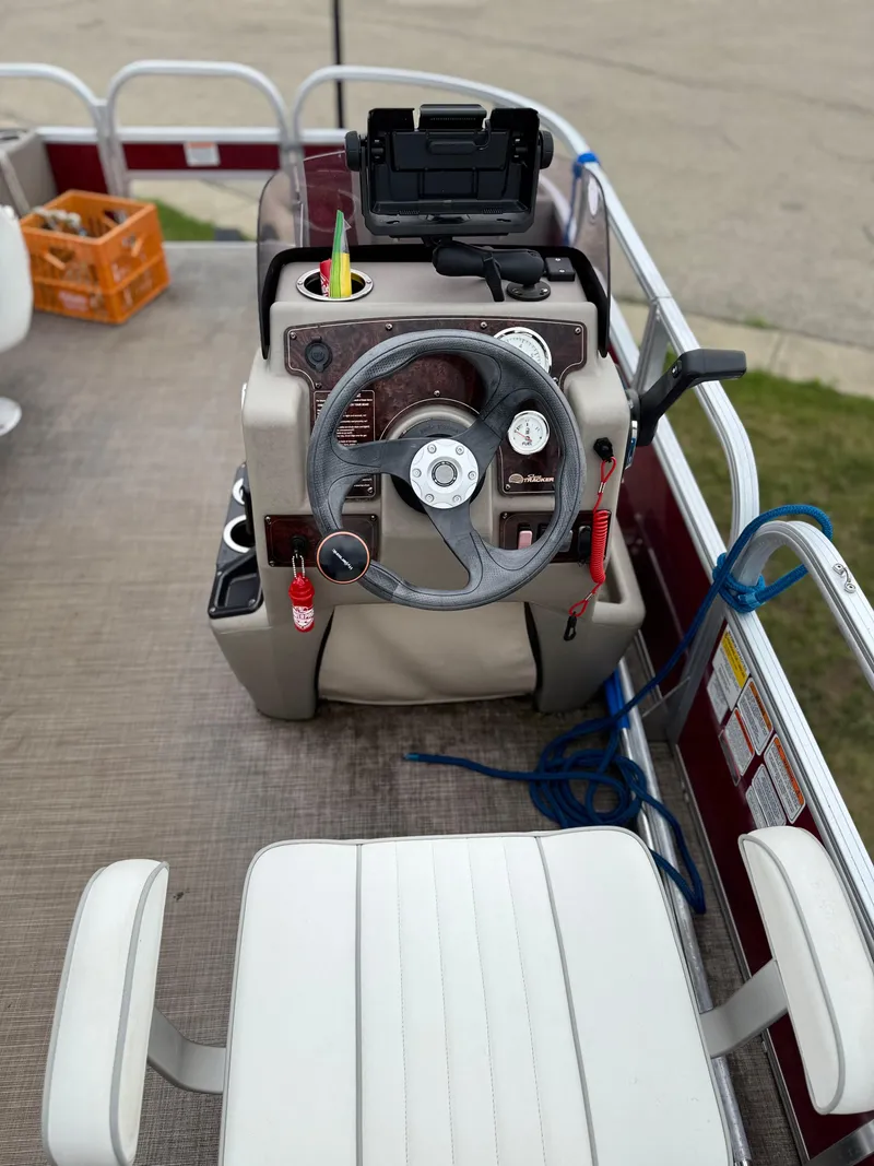 Slide: The Image of 2022 Sun Tracker Bass Buggy 18 DLX steering console with controls and seating. - 16