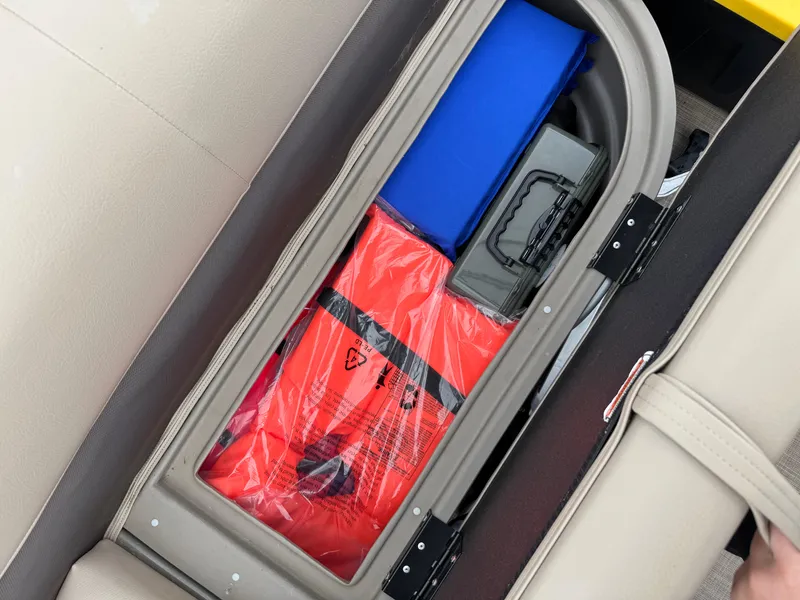 Slide: The Image of Storage compartment in 2022 Sun Tracker Bass Buggy 18 DLX, containing safety gear and equipment. - 24