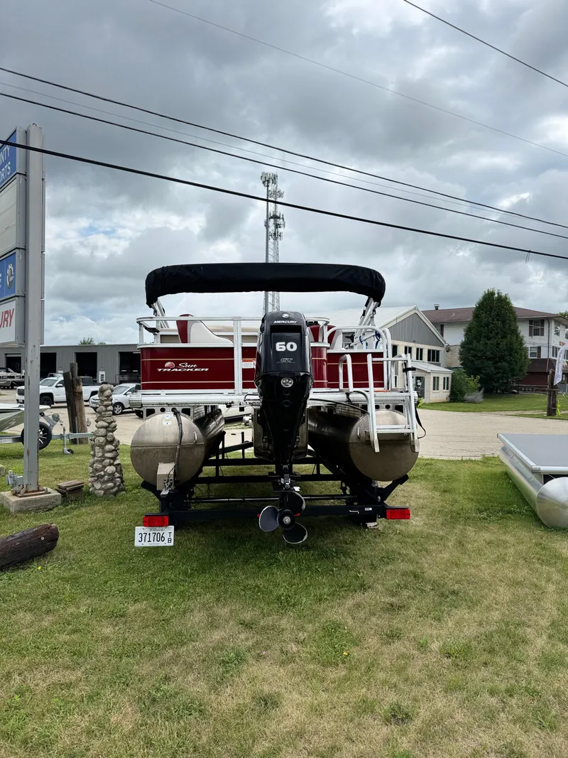 Slide: The Image of 2022 Sun Tracker Bass Buggy 18 DLX pontoon boat with 60 HP engine, parked on grass. - 8