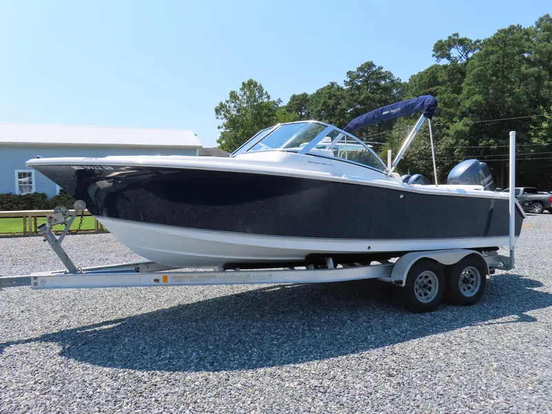 Slide: The Image of 2013 Sea Hunt Escape 211 LE boat on trailer, parked outdoors. - 0