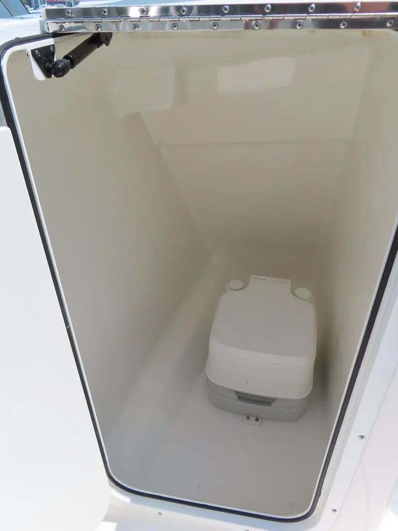 Slide: The Image of 2013 Sea Hunt Escape 211 LE boat compartment with portable toilet. - 21