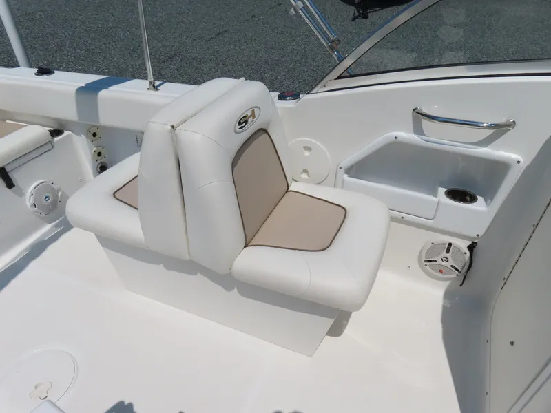 Slide: The Image of White seating area on 2013 Sea Hunt Escape 211 LE boat, featuring beige accents and built-in speaker. - 22