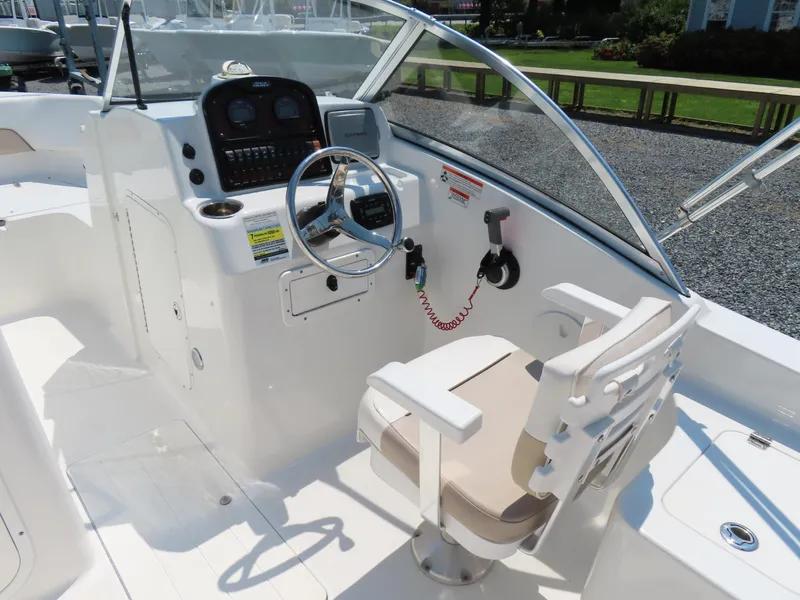 Slide: The Image of 2013 Sea Hunt Escape 211 LE boat cockpit with steering wheel and control panel. - 24