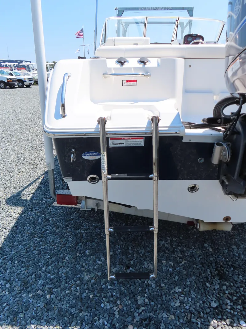 Slide: The Image of 2013 Sea Hunt Escape 211 LE boat with rear ladder and American flag in background. - 6