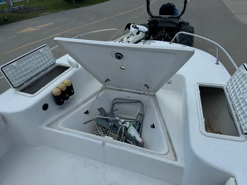 Slide: The Image of 2011 Carolina Skiff 25 Elite SS boat with open storage compartments and visible equipment. - 15