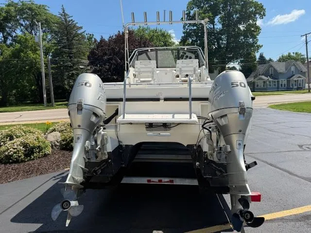 Slide: The Image of 1998 Kevlacat Series 2000 Cuddy Cabin OB with dual outboard motors, parked on a driveway. - 2