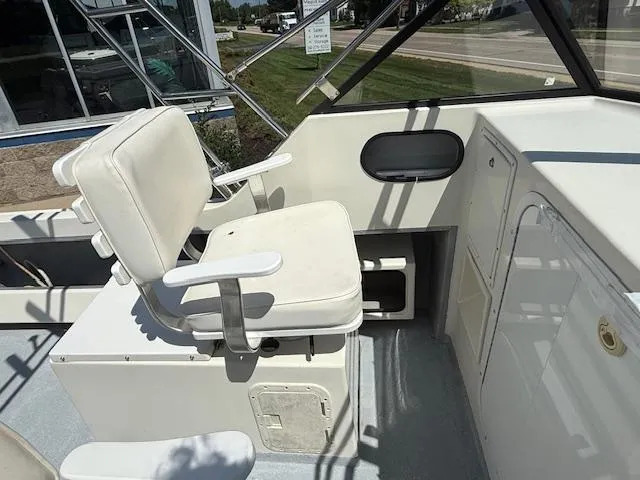 Slide: The Image of 1998 Kevlacat Series 2000 Cuddy Cabin OB interior with white seating and control area. - 7