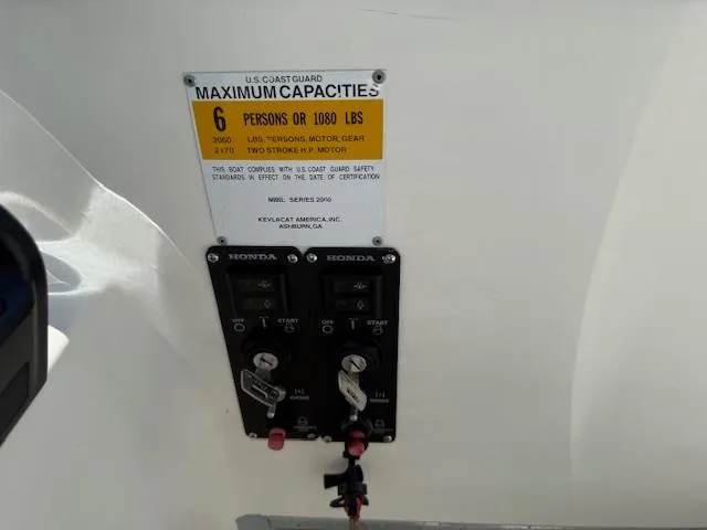 Slide: The Image of 1998 Kevlacat Series 2000 Cuddy Cabin OB capacity label and Honda controls. - 8