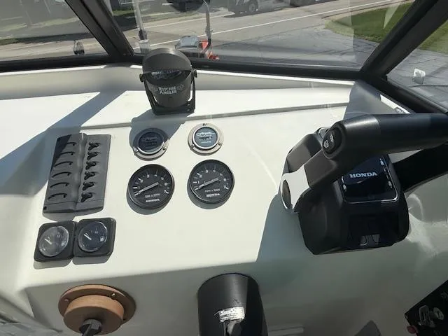 Slide: The Image of Dashboard of a 1998 Kevlacat Series 2000 Cuddy Cabin OB with Honda controls and gauges. - 9