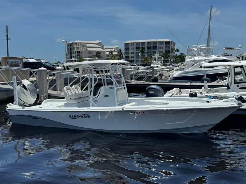 Slide: The Image of 2019 Blue Wave 2800 Pure Hybrid boat docked at marina under clear blue sky. - 0