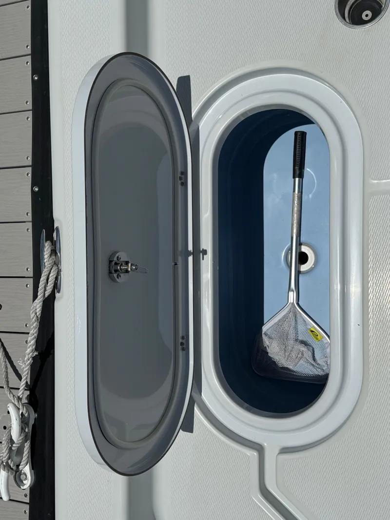 Slide: The Image of Open storage compartment on 2019 Blue Wave 2800 Pure Hybrid boat with a net inside. - 16