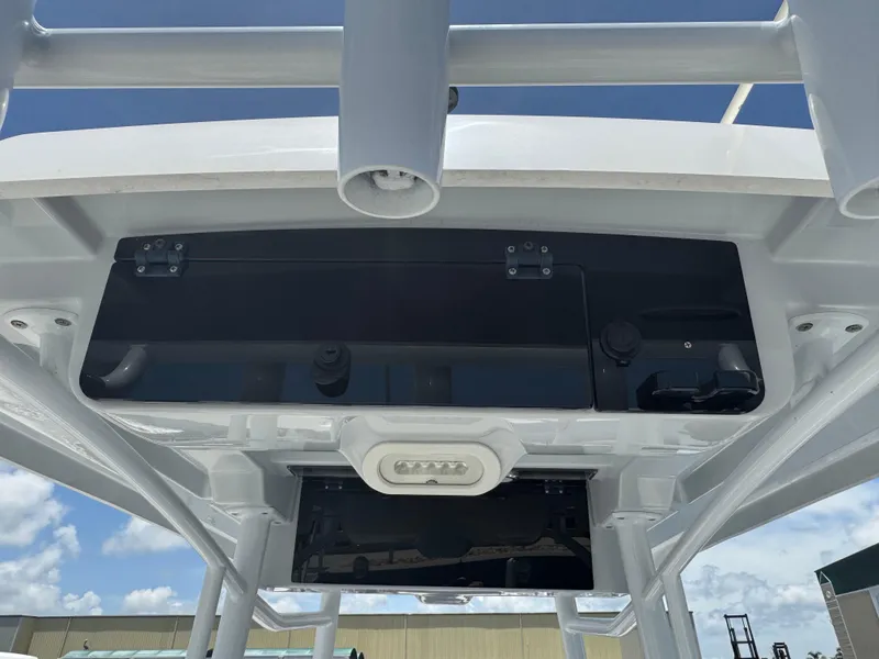Slide: The Image of 2019 Blue Wave 2800 Pure Hybrid boat console, featuring storage and rod holders. - 22