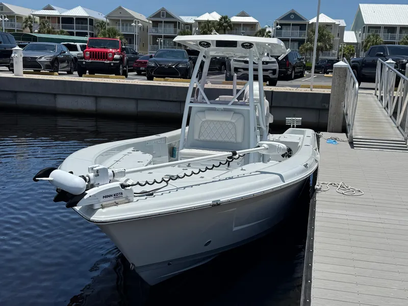 Slide: The Image of 2019 Blue Wave 2800 Pure Hybrid boat docked at marina with modern buildings in background. - 4