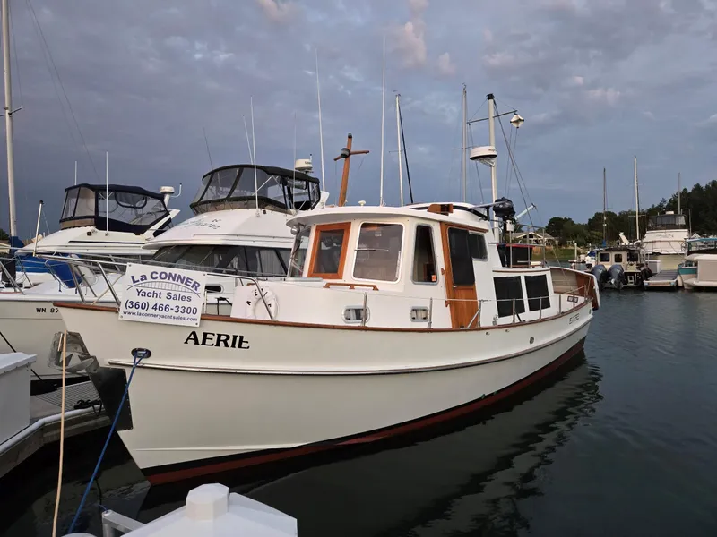 The Image of 1989 Eagle Pilothouse boat named "Aerie" docked at marina under cloudy sky. - 0