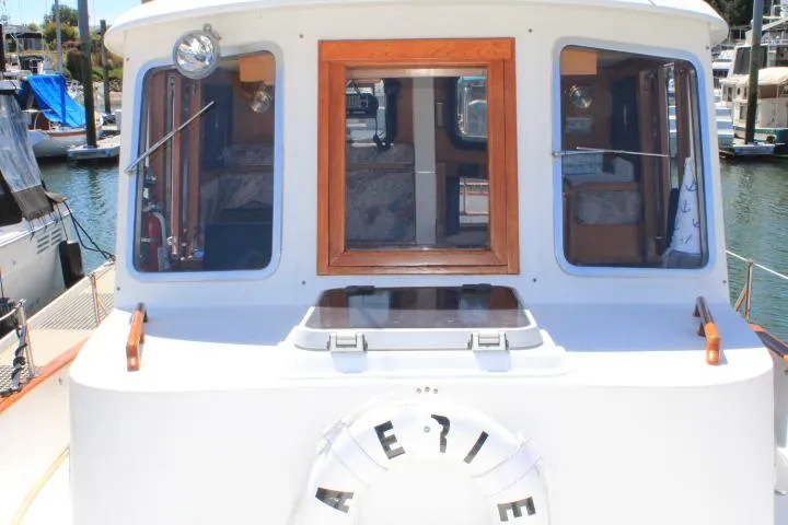 Slide: The Image of 1989 Eagle Pilothouse boat docked at marina, featuring wooden accents and life preserver. - 10