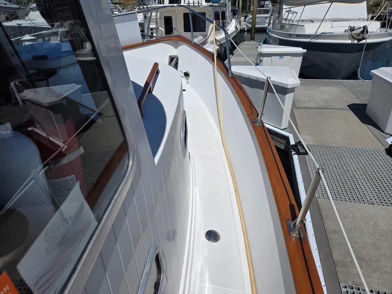 Slide: The Image of 1989 Eagle Pilothouse boat docked, showcasing sleek deck design and polished wood accents. - 12