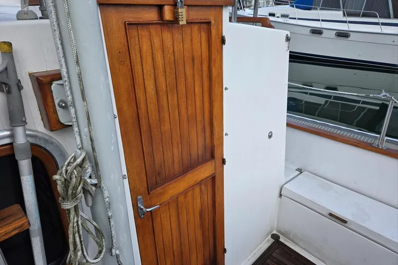 Slide: The Image of 1989 Eagle Pilothouse boat with wooden door and nautical ropes on deck. - 19