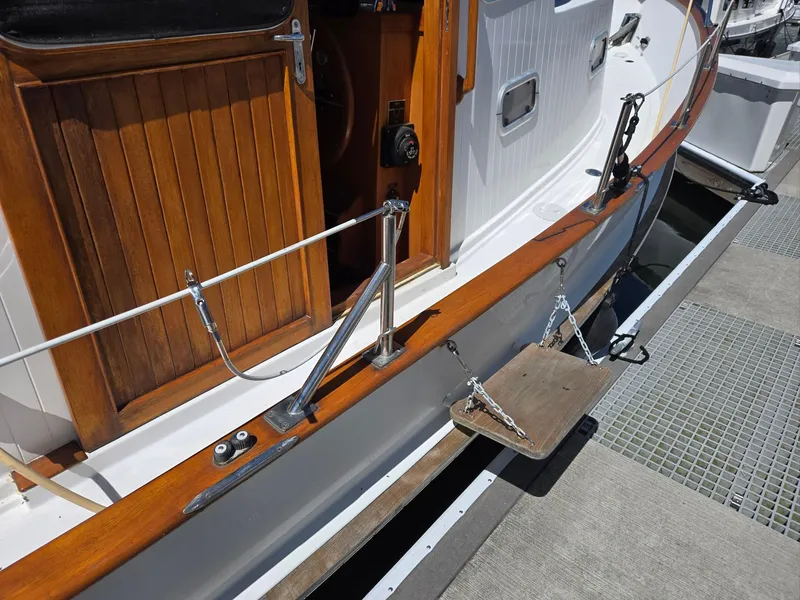 Slide: The Image of 1989 Eagle Pilothouse boat with wooden door and deck details at a marina. - 25