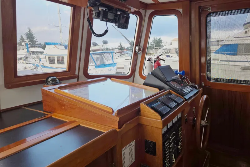 Slide: The Image of 1989 Eagle Pilothouse interior with wooden dashboard and marina view through windows. - 28