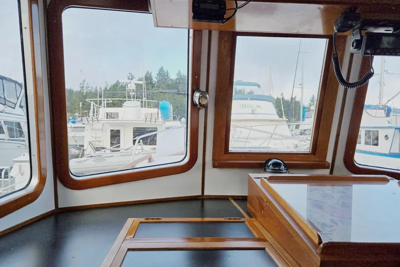 Slide: The Image of 1989 Eagle Pilothouse interior with marina view through large windows. - 36