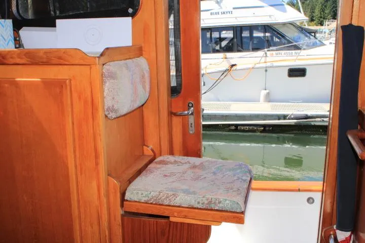 Slide: The Image of Interior of a 1989 Eagle Pilothouse boat with wooden seating and marina view. - 40