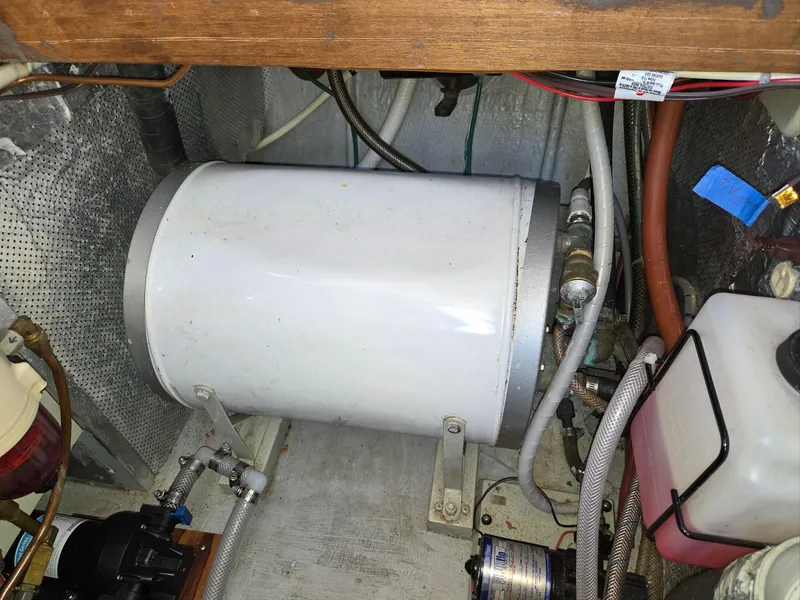 Slide: The Image of 1989 Eagle Pilothouse engine room with water heater and various mechanical components. - 49