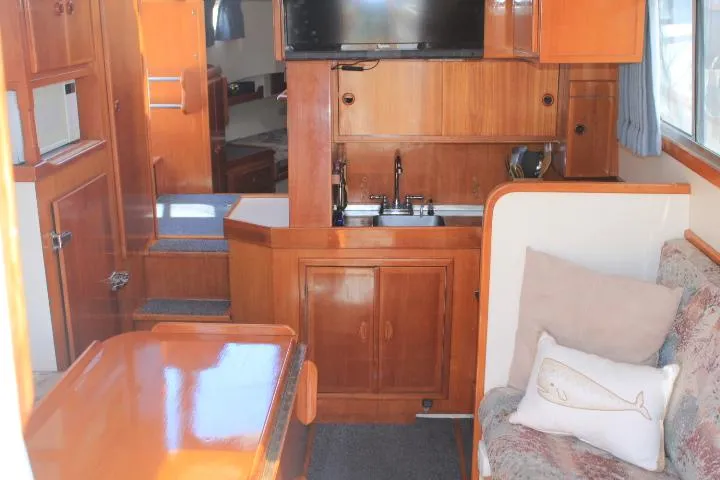 Slide: The Image of Interior of a 1989 Eagle Pilothouse boat with wooden cabinetry and cozy seating area. - 51