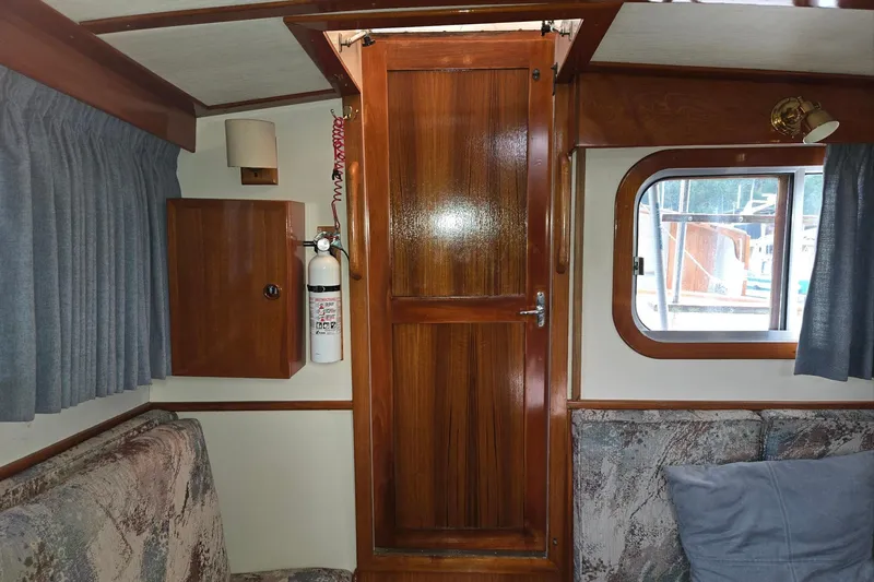 Slide: The Image of 1989 Eagle Pilothouse interior with wooden door, window, and fire extinguisher. - 52