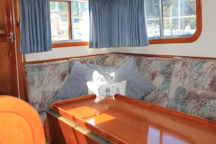 Slide: The Image of Cozy interior of 1989 Eagle Pilothouse with cushioned seating and wooden table. - 53