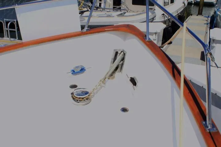Slide: The Image of 1989 Eagle Pilothouse boat deck with anchor chain and railing at marina. - 13