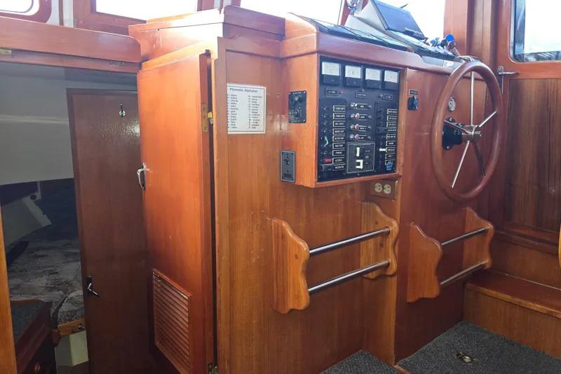 Slide: The Image of 1989 Eagle Pilothouse interior with wooden paneling, control panel, and steering wheel. - 30