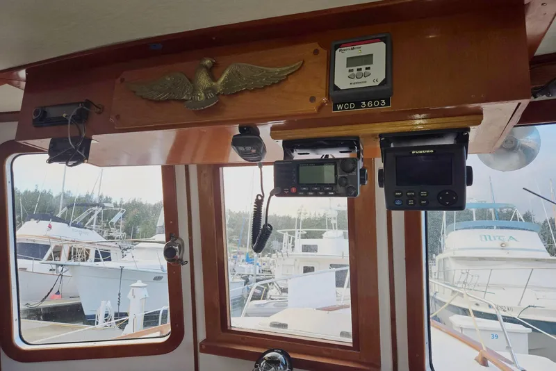 Slide: The Image of 1989 Eagle Pilothouse interior with navigation equipment and marina view. - 35
