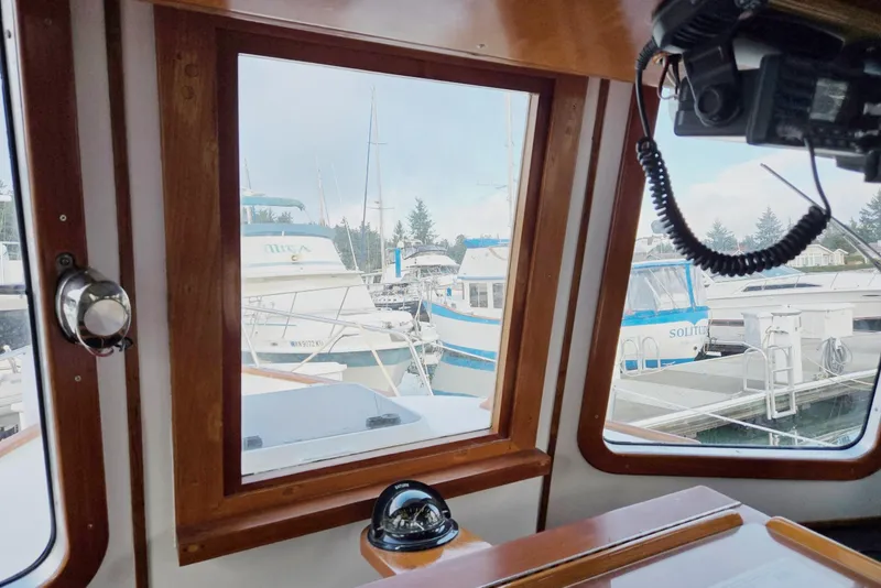 Slide: The Image of 1989 Eagle Pilothouse interior view with marina and boats outside window. - 37