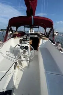 Slide: The Image of 1979 Morgan Out Island sailboat with red canopy, steering wheel, and open cabin on a sunny day. - 6