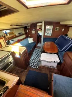 Slide: The Image of Interior of a 1979 Morgan Out Island sailboat with cozy seating and dining area. - 7