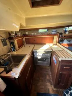 Slide: The Image of 1979 Morgan Out Island yacht kitchen with wooden cabinets and compact appliances. - 8