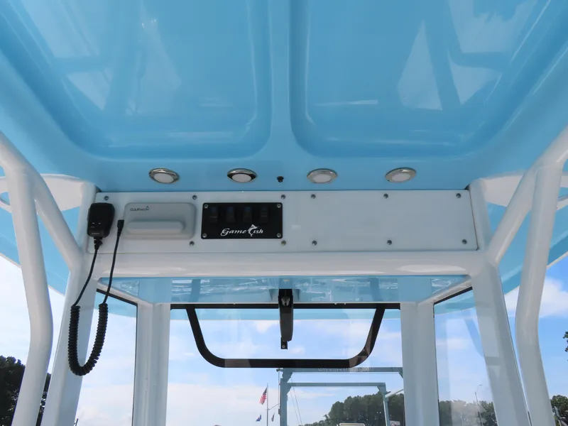 Slide: The Image of 2017 Sea Hunt Gamefish 27 boat console with blue canopy and control panel. - 27