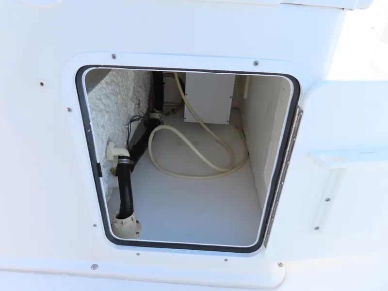 Slide: The Image of Storage compartment on a 2017 Sea Hunt Gamefish 27 boat, showing interior hoses and fittings. - 32