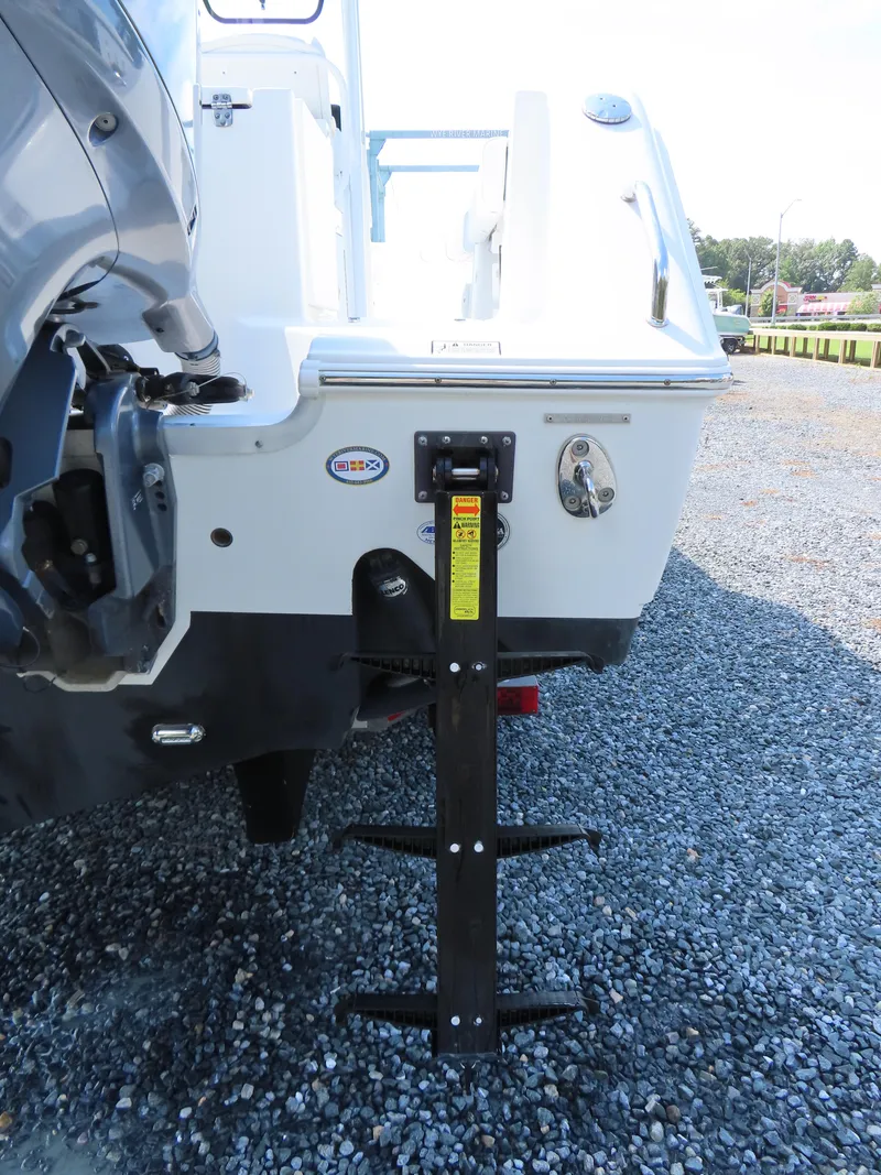 Slide: The Image of 2017 Sea Hunt Gamefish 27 boat with a mounted ladder on gravel surface. - 6