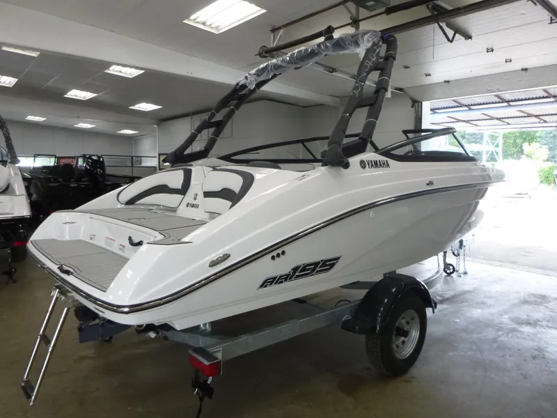 Slide: The Image of 2025 Yamaha AR195 boat in showroom, sleek white design on trailer. - 4