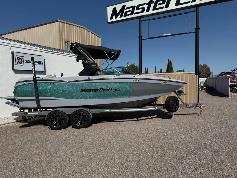 The Image of 2022 MasterCraft XStarS boat on trailer at dealership, side view. - 0