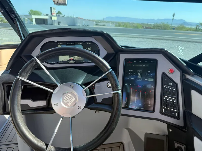 Slide: The Image of 2022 MasterCraft XStarS dashboard with steering wheel and digital controls. - 12