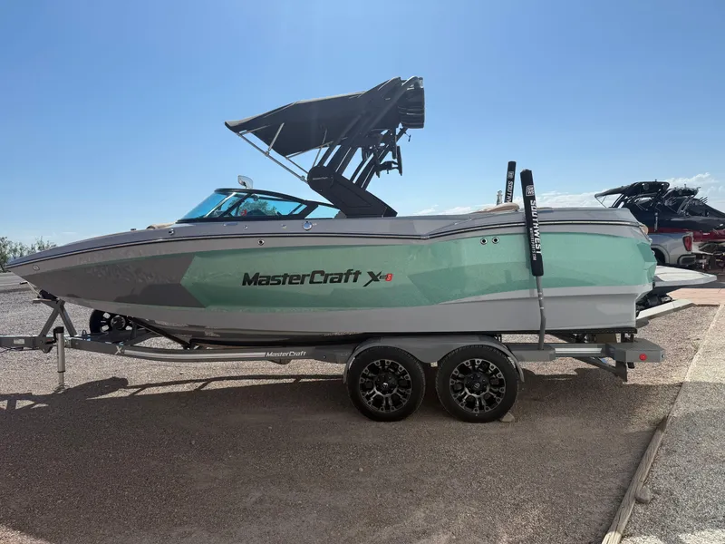 Slide: The Image of 2022 MasterCraft XStarS boat on trailer under clear blue sky. - 3